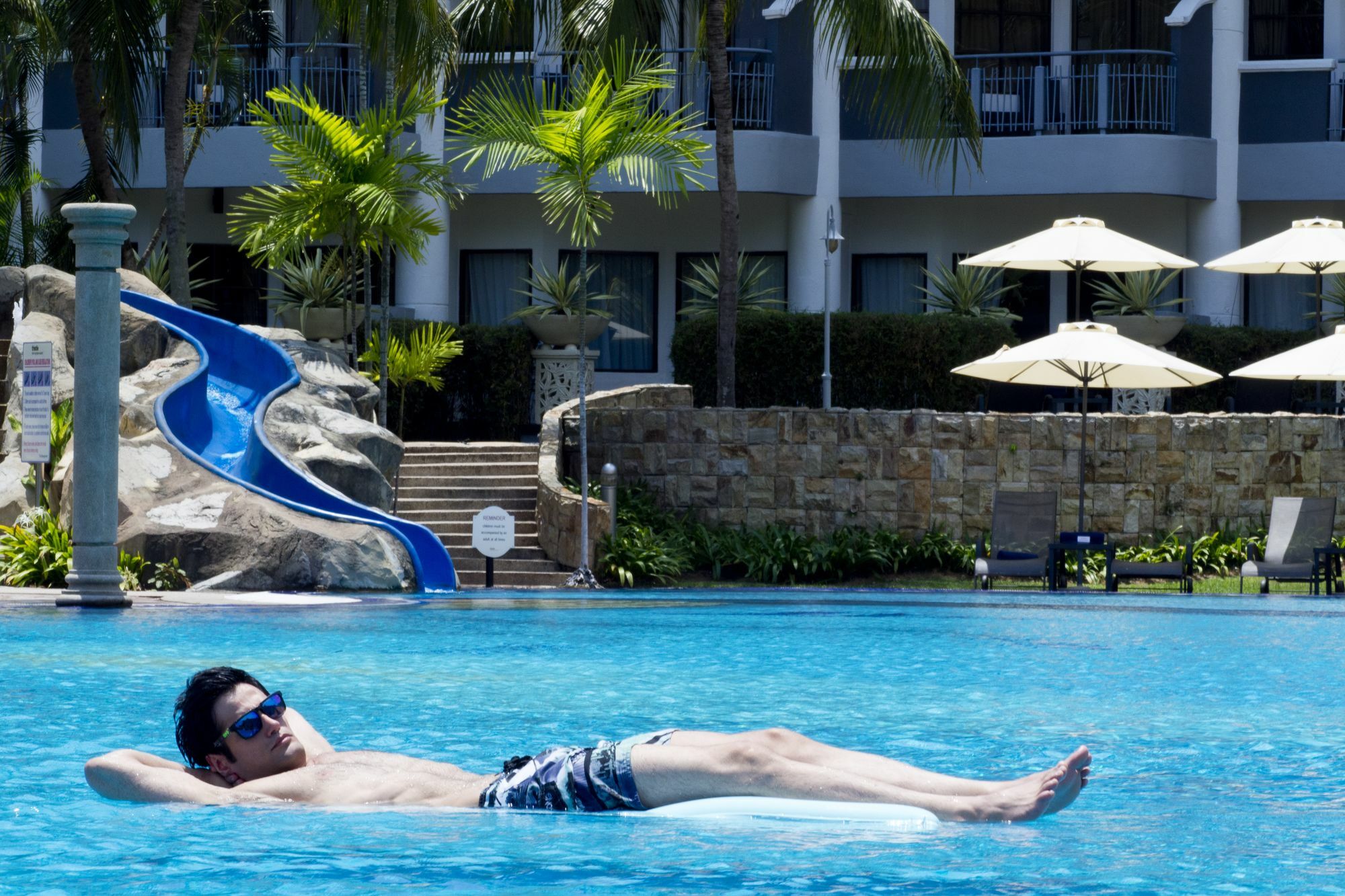 Thistle Port Dickson Resort Buitenkant foto A man relaxing on a pool float